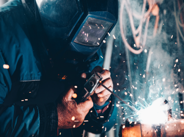 Welder wearing a protective helmet while welding metal